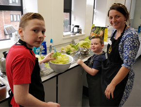 A parent and two child attend a Nutrition event and are prepping food